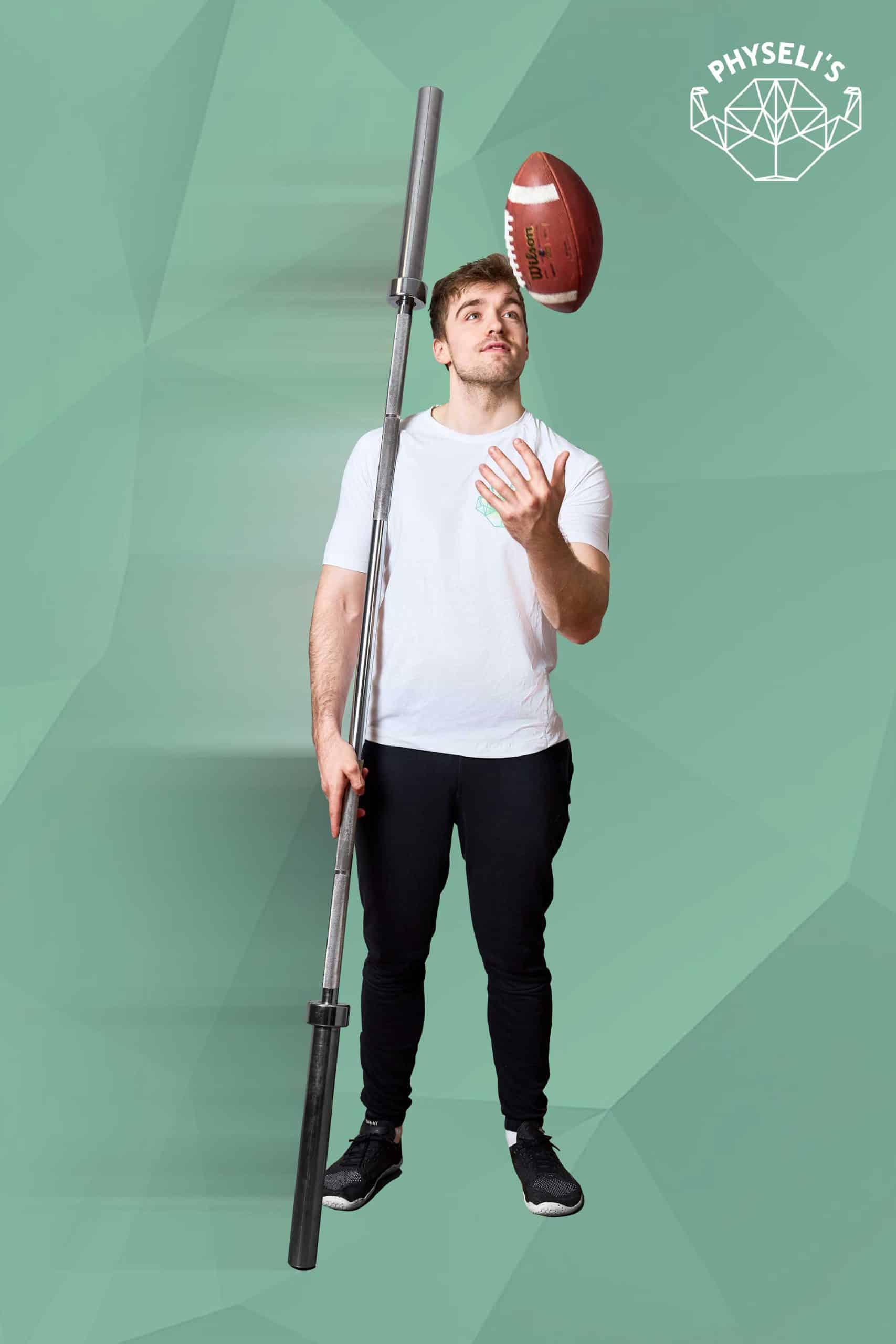 Ein sportlicher, junger Mann hält eine Gewichtstange und jongliert einen